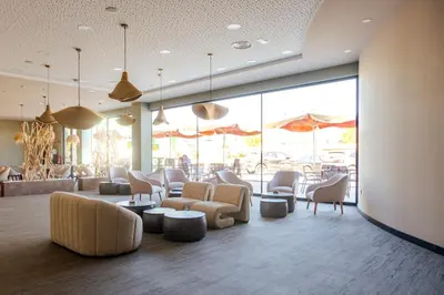 a waiting room with chairs and tables and windows at La Finca in Lugo