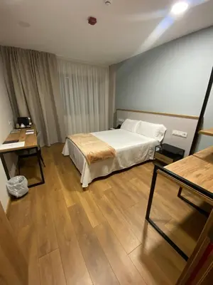 a bedroom with a bed and a wooden floor at La Finca in Lugo