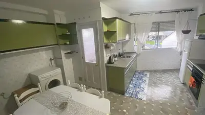 a kitchen with green cabinets and a washing machine at As pontes apartamento in Puentes de García Rodríguez