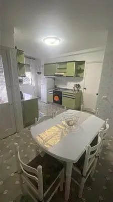 a kitchen with a white table and white chairs at As pontes apartamento in Puentes de García Rodríguez