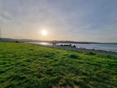 a view of a beach with the sun in the distance at As pontes apartamento in Puentes de García Rodríguez