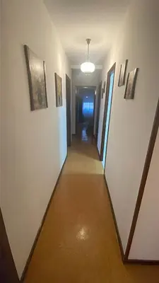 a hallway in a building with paintings on the walls at As pontes apartamento in Puentes de García Rodríguez