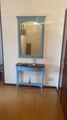 a blue table with a mirror on a wall at As pontes apartamento in Puentes de García Rodríguez