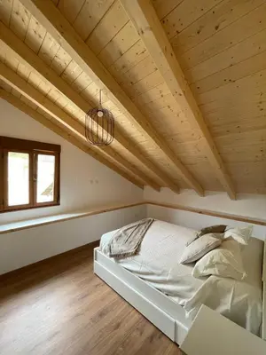 a bed in a room with a wooden ceiling at A Chupiña in Balboa