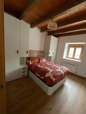 a bedroom with a bed and a wooden floor at A Chupiña in Balboa