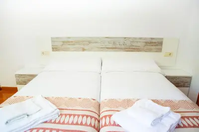 a bed with two white towels on top of it at Welcome A Casiña de Arcos de Furcos in Cuntis