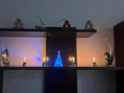 a shelf with a blue christmas tree and candles at Welcome A Casiña de Arcos de Furcos in Cuntis