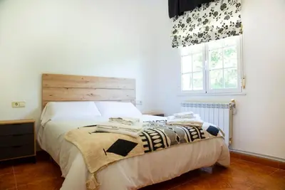 a bedroom with a bed with a wooden headboard and a window at Welcome A Casiña de Arcos de Furcos in Cuntis