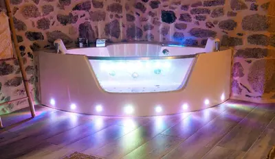 a bath tub in a room with a wooden floor at Apartamentos Muralla Sacra in Sober
