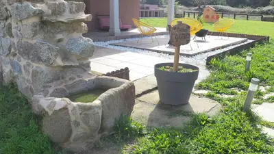 a stone wall with a planter with a sign on it at Apartamentos Muralla Sacra in Sober