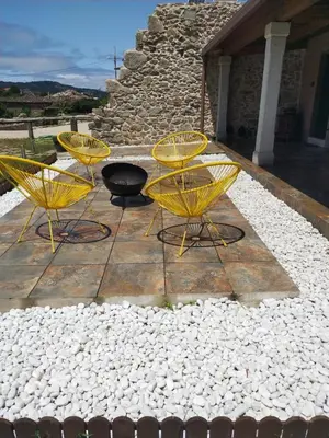 three yellow chairs and a table on a patio at Apartamentos Muralla Sacra in Sober