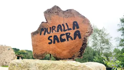 a wooden sign on top of a rock at Apartamentos Muralla Sacra in Sober