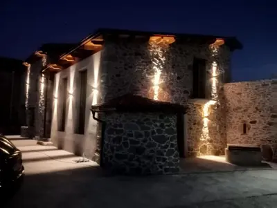 a stone building with lights on it at night at Apartamentos Muralla Sacra in Sober