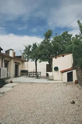 a patio with a table and a tree next to a building at Casa Trillo en centro de Monforte de Lemos in Monforte de Lemos