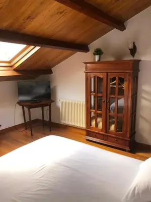 a bedroom with a bed and a cabinet and a television at Pazo da Trave in Viveiro