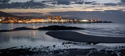 a view of a city from the beach at night at Refugio de mar in Barreiros