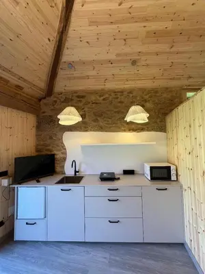 a kitchen with white cabinets and a sink and two lights at Bella Casa Araujo in Lamas