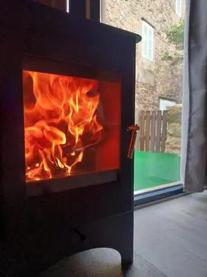 a fireplace with flames in it with a window at Bella Casa Araujo in Lamas
