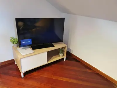a flat screen tv sitting on a stand in a room at Apartamento entero Frama Caldas in Caldas de Reis
