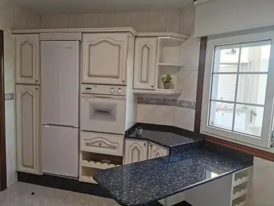 a kitchen with white cabinets and a black counter top at Apartamento entero Frama Caldas in Caldas de Reis
