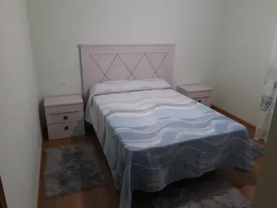 a bedroom with a bed and two night stands at Casa Lavandeira in Ourense