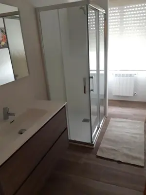 a bathroom with a sink and a glass shower at Casa Lavandeira in Ourense