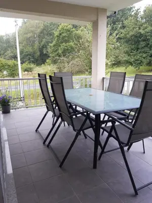 a glass table and chairs on a patio at Casa Lavandeira in Ourense