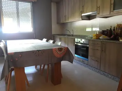 a kitchen with a table with chairs and a stove at Casa Lavandeira in Ourense