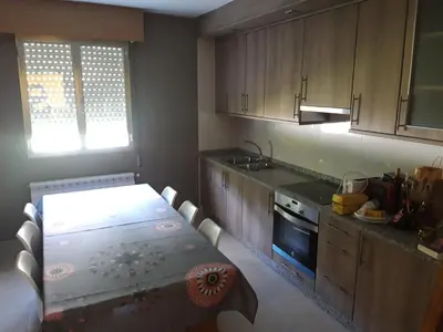 a kitchen with a table and a stove top oven at Casa Lavandeira in Ourense