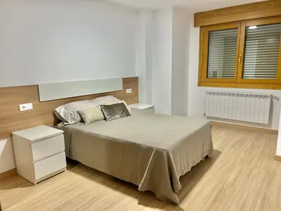 a bedroom with a large bed and a window at Piso de diseño in Verín