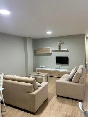 a living room with two couches and a flat screen tv at Piso de diseño in Verín