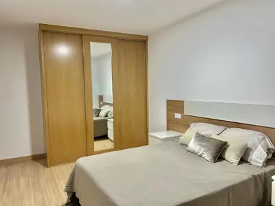 a bedroom with a large bed and a mirror at Piso de diseño in Verín