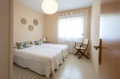 a bedroom with a bed and a window and a chair at Casa Miño Golf in Miño