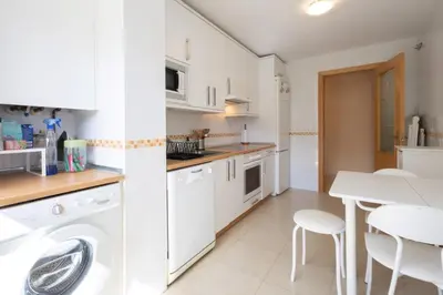 a kitchen with a washing machine and a table at Casa Miño Golf in Miño