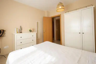 a bedroom with a white bed and a dresser at Casa Miño Golf in Miño