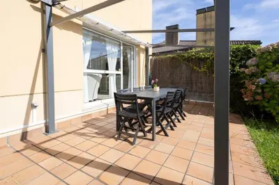 a patio with a table and chairs on it at Casa Miño Golf in Miño