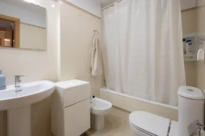 a white bathroom with a toilet and a sink at Casa Miño Golf in Miño