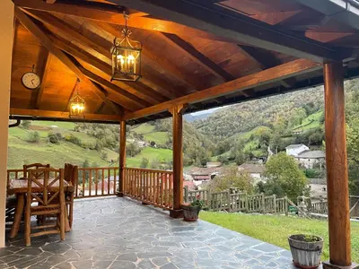 a wooden patio with a view of a mountain at Los Diales in Cangas del Narcea