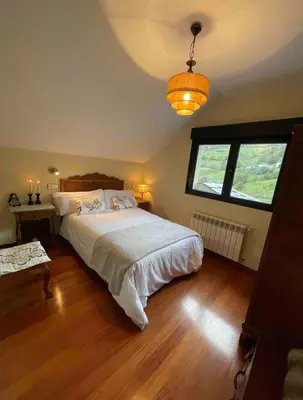 a bedroom with a large bed and a window at Los Diales in Cangas del Narcea