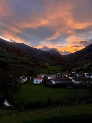 a sunset over a town in a valley with mountains at Los Diales in Cangas del Narcea