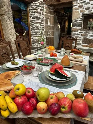 a table with a bunch of fruit on it at O Forno de Catuxa Cottage & Roman Wall in Lugo