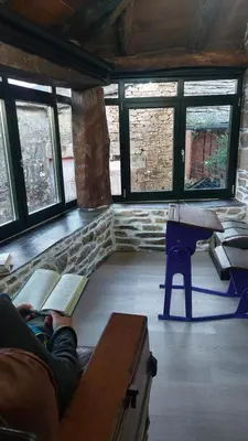 a person laying on a couch in a room with books at O Forno de Catuxa Cottage & Roman Wall in Lugo
