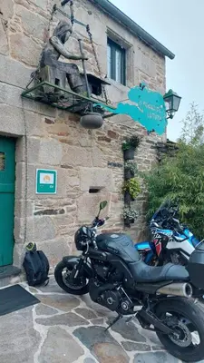 a motorcycle parked in front of a building at O Forno de Catuxa Cottage & Roman Wall in Lugo