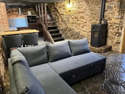 a living room with a couch and a stove at La Casina de Gelo in Riego de Ambros