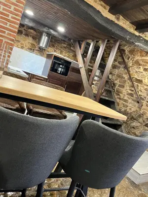 a wooden table and two chairs in a room at La Casina de Gelo in Riego de Ambros