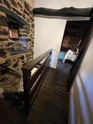 a stairway in a room with a stone wall at La Casina de Gelo in Riego de Ambros