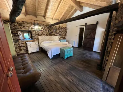 a bedroom with a bed and a couch in a room at La Casina de Gelo in Riego de Ambros