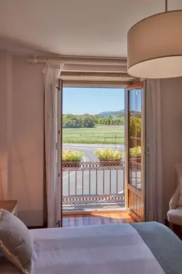 a bedroom with a bed and a view of a balcony at Casa Condomiña in Amés
