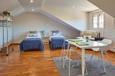 a attic room with two beds and a table at Casa Condomiña in Amés