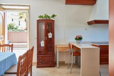 a kitchen with a table and a wooden cabinet at Casa Condomiña in Amés